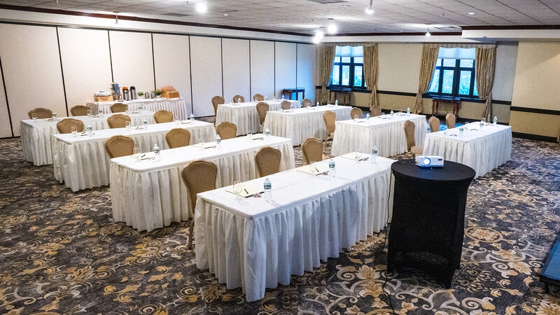 Private room setup with several long tables and speaker stand