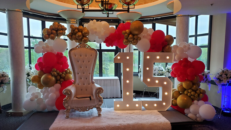 Chair with balloon decorations and large 15 sign