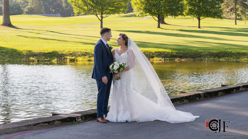 Bride and groom standing by lake