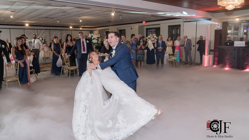 Bride and groom dancing in party room in front of guests