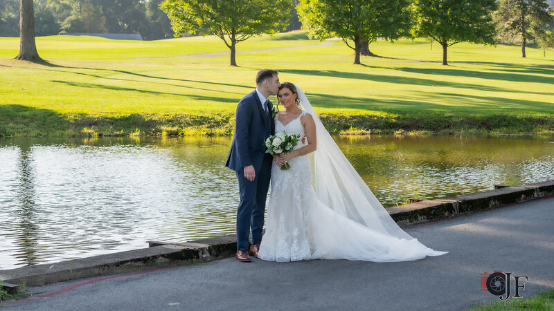 Groom kissing bride on forehead outside