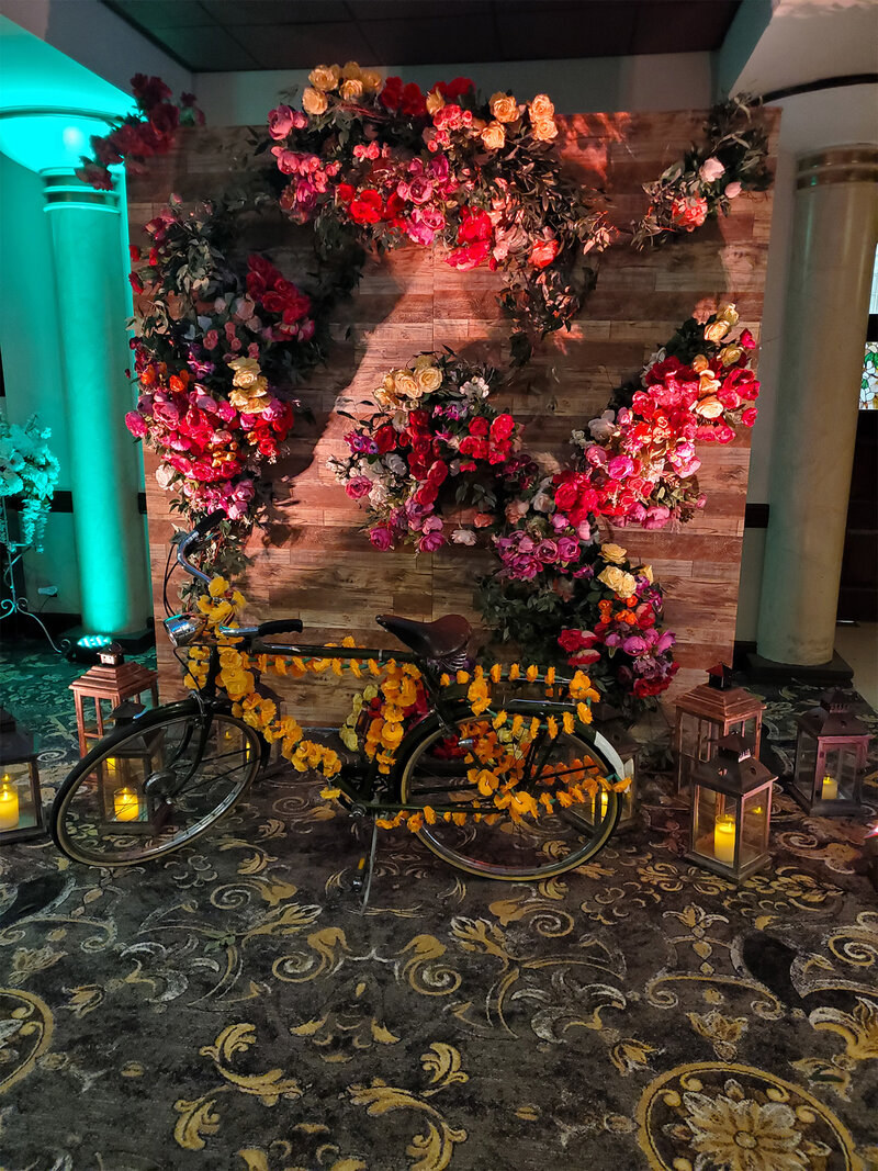 Wall decorated with flowers and bicycle covered with flowers