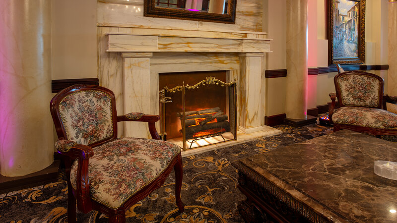 Fireplace with two chairs in private reception room