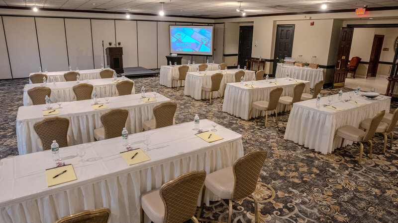 Long tables with view of projector screen in private event room