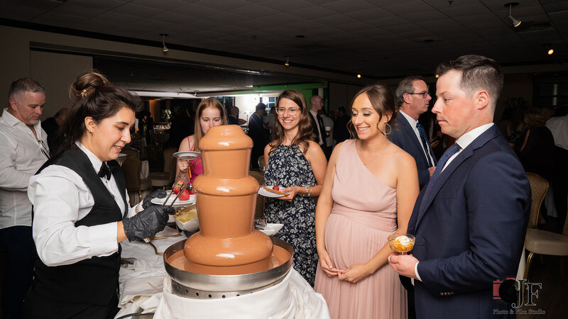 Wedding guests being served from chocolate fountain